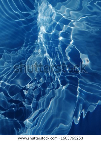 Reflection of sunlight to surface of blue water. Water splash background