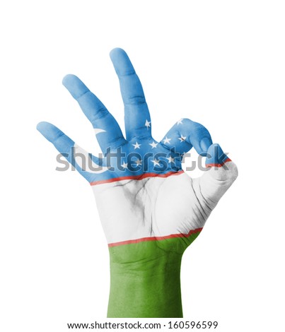 Hand making Ok sign, Uzbekistan flag painted as symbol of best quality, positivity and success - isolated on white background