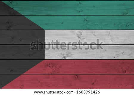 Kuwait flag depicted in bright paint colors on old wooden wall. Textured banner on rough background