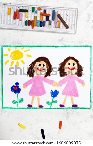 Photo of colorful drawing: Identical twins. Two smiling sisters look the same