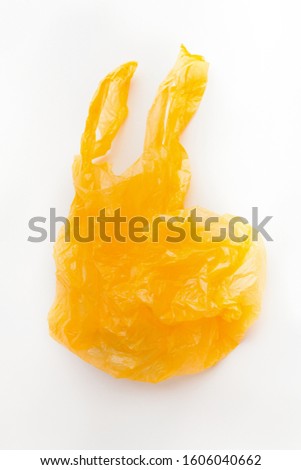 Yellow plastic shopping bag flying over white background, isolated, copy space for ad