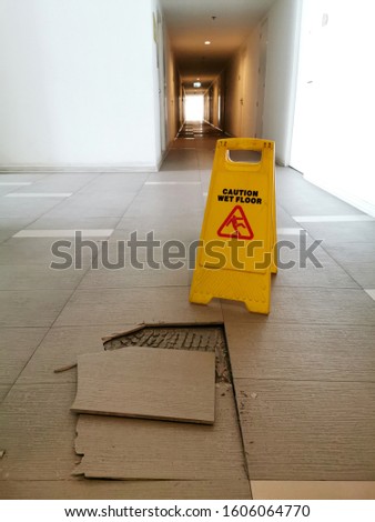 Broken tile floor and yellow caution on the floor