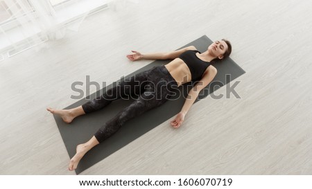 Calm girl relaxing in savasana pose on mat after exercising at home, panorama Royalty-Free Stock Photo #1606070719