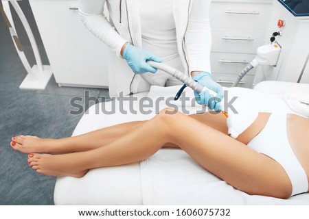 Laser hair removal on beautiful female legs. Laser cosmetologist doing legs smooth and hair free.
