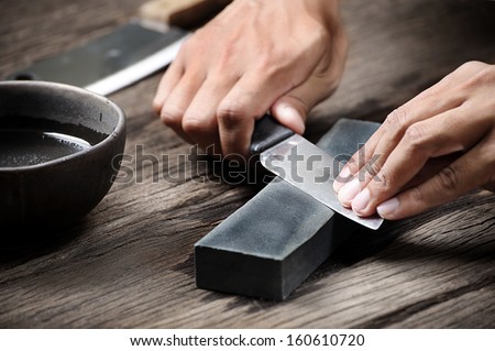 sharpening the knife with whetstone Royalty-Free Stock Photo #160610720