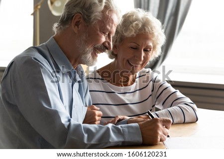Satisfied senior couple at lawyer office signing prenuptial agreement marriage articles, 70s spouses make decision buying medical life health insurance, concept of testament last will and inheritance Royalty-Free Stock Photo #1606120231