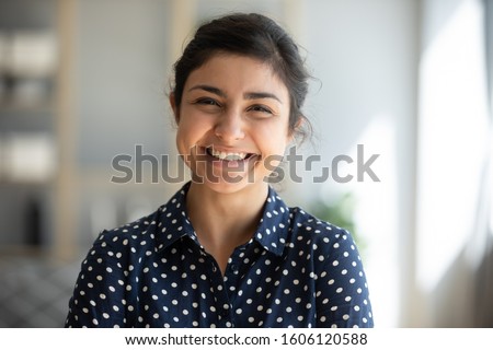 Cheerful beautiful indian girl student professional standing at home in office looking at camera, happy confident entrepreneur hindu lady laughing face posing alone, head shot close up view portrait Royalty-Free Stock Photo #1606120588