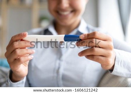 Happy pregnant young fertile woman expectant mother hold positive result pregnancy test in hands, smiling lady expect baby after infertility treatment in vitro fertilization concept, close up view