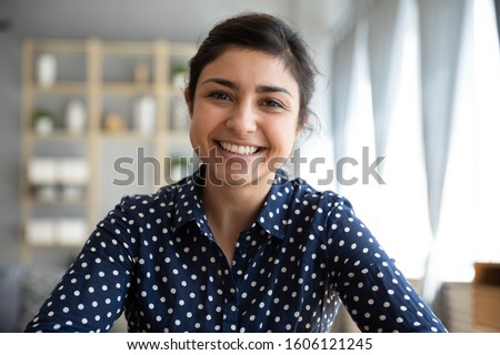 Happy young indian woman blogger applicant teacher sit at home office look at camera doing online job interview during video chat conference call record vlog teaching on webinar in app, webcam view Royalty-Free Stock Photo #1606121245