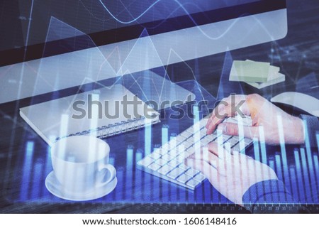 Multi exposure of graph with man typing on computer in office on background. Concept of hard work.