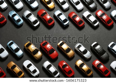 Top view of Parked toy cars on a black background like a car parking lot.
