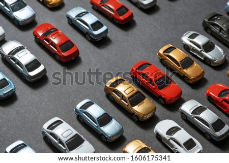 Top view of Parked toy cars on a black background like a car parking lot.