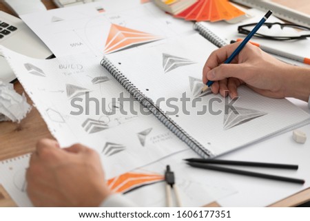 Graphic designer drawing sketches logo design. The concept of a new brand. Professional creative occupation with idea.
