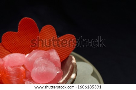 Heart shaped candy In a bowl  on a black background. This image is a symbol to show the love in every season such as Valentine's Day.