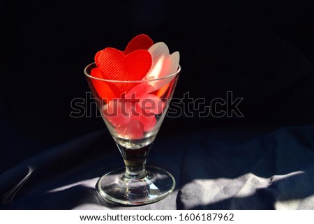 Heart shaped candy In a glass  on a black background. This image is a symbol to show the love in every season such as Valentine's Day.