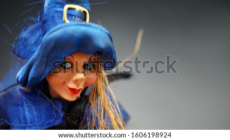 puppet for the epiphany of a young witch with look to the right and blue clothes. black background, copy space