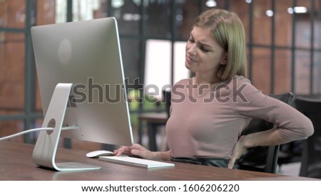 Tired Woman having Back Pain while Working on Computer