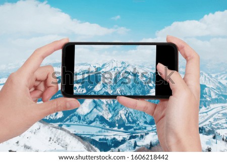 photo shooting on smartphone in tourist journey tourist taking photo of snow mountain peak in japan./travel concept.