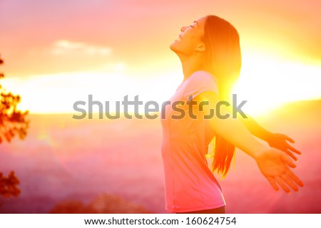 Free happy woman enjoying nature sunset. Freedom, happiness and enjoyment concept of beautiful multiracial Asian Caucasian girl in her 20s. Image from Grand Canyon, United States.