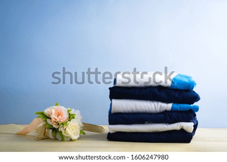 laundry Stack and messy clothes on table against light background

