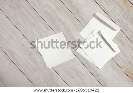 White blank envelopes and post card on the wood desk, top view.
