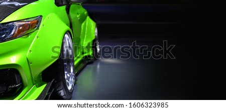 Front headlights of green modify car on black background,copy space	 Royalty-Free Stock Photo #1606323985
