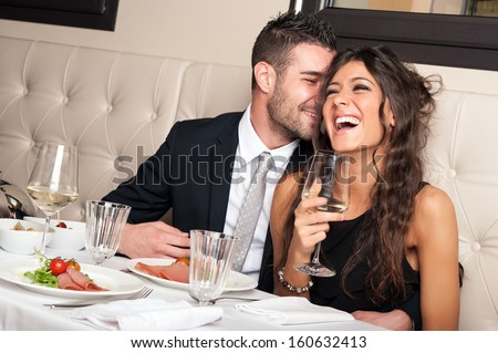 Attractive elegant young couple drinking a cocktail at the restaurant. Royalty-Free Stock Photo #160632413