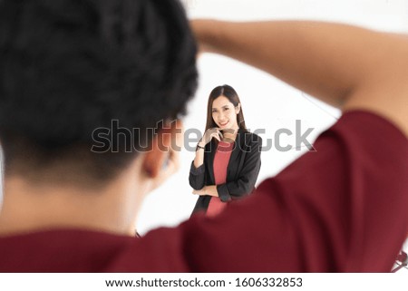 An Asian beautiful woman poses for a photo and she smiles at the camera. With an Asian photographer With the backdrop of a studio. Concept couple.hobby,lifestyle 
