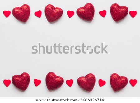 Stock photo of big and small red hearts on a white background. Hearts at the top and bottom with a space for text