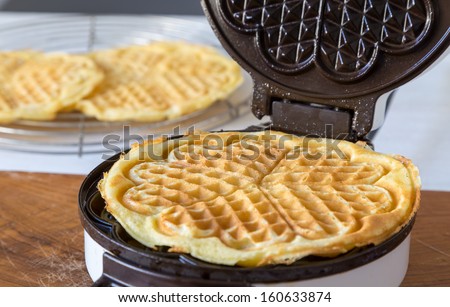 Homemade waffles are cooked in a waffle iron Royalty-Free Stock Photo #160633874