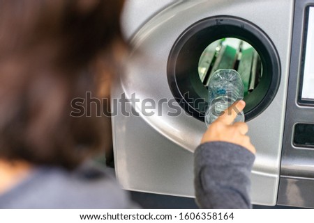 Woman at the reverse vending machine recycle plastic bottles, ecology concept Royalty-Free Stock Photo #1606358164