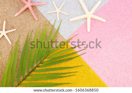 Flat lay summer vacation. Palm leaf and starfishes on a geometric shiny background
