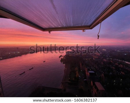 Sunrise with red purple sky above Greenwich peninsula and Thames river viewed from the Kelson House top flour in Isle of Dogs