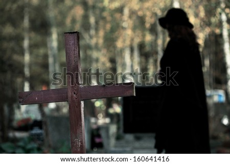 Shape of woman moving alone at cemetery