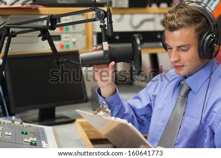 Well dressed focused radio host moderating sitting in studio at college
