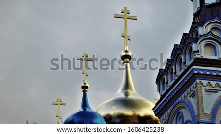 Gold and blue domes of a church with crosses on a background of sky.