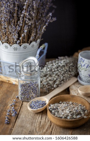 Dried lavender. Lavender seeds, buds and flowers - aromatherapy and herbal medicine. Herbal tea in a wooden spoon, a can with tea on a wooden table.
