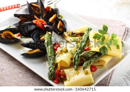 Pasta with mussels and asparagus on complex background