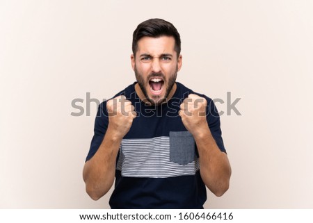 Young handsome man with beard over isolated background frustrated by a bad situation