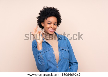 African american woman over isolated background showing an ok sign with fingers