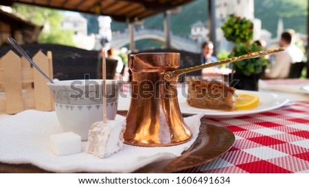 Traditional Turkish coffee and turkish delight. View of Mostar Old bridge in the background, Bosnia and Herzegovina.  Royalty-Free Stock Photo #1606491634