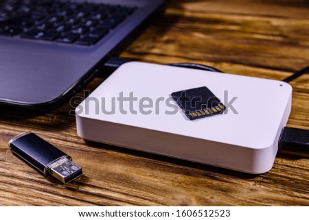 Modern laptop, sd card, flash memory card and ssd hard drive on wooden desk