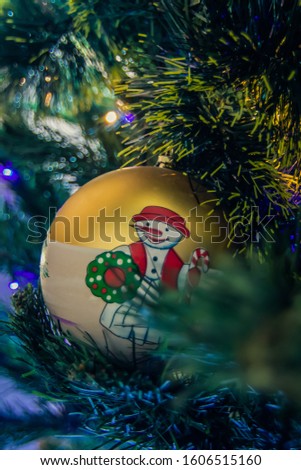 Snowman pictured on christmas ball on Christmas tree decorated. Snowman and Christmas ball. Holidays celebration concept
