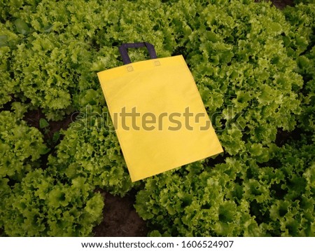 beautiful yellow fabric Reusable Eco Friendly Bag on green background, Polypropylene Shopping Bags, Environment Friendly Concept. Reduce, Reuse, Recycle, save earth