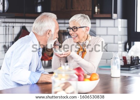 Senior couple enjoying their time at home, in kitchen with breakfast in the morning. Closeup picture with copy space