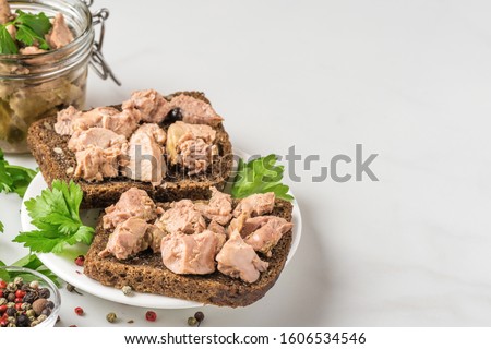 Cod liver in a jar with sandwiches with liver on white background. Natural source of omega 3 and vitamin D. close up with copy space