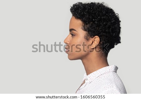 African young woman profile side close up view face isolated on grey background aside, copy free space for motivational thoughts wise quotes to inspire you or commercial text offer concept studio shot