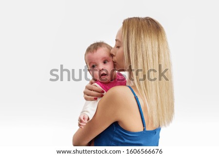 Mother kisses a crying baby girl