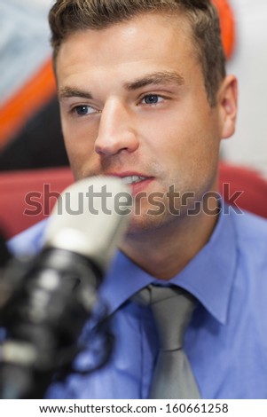 Well dressed concentrating radio host moderating in studio at college