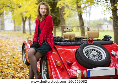Woman in red and car at autumn park